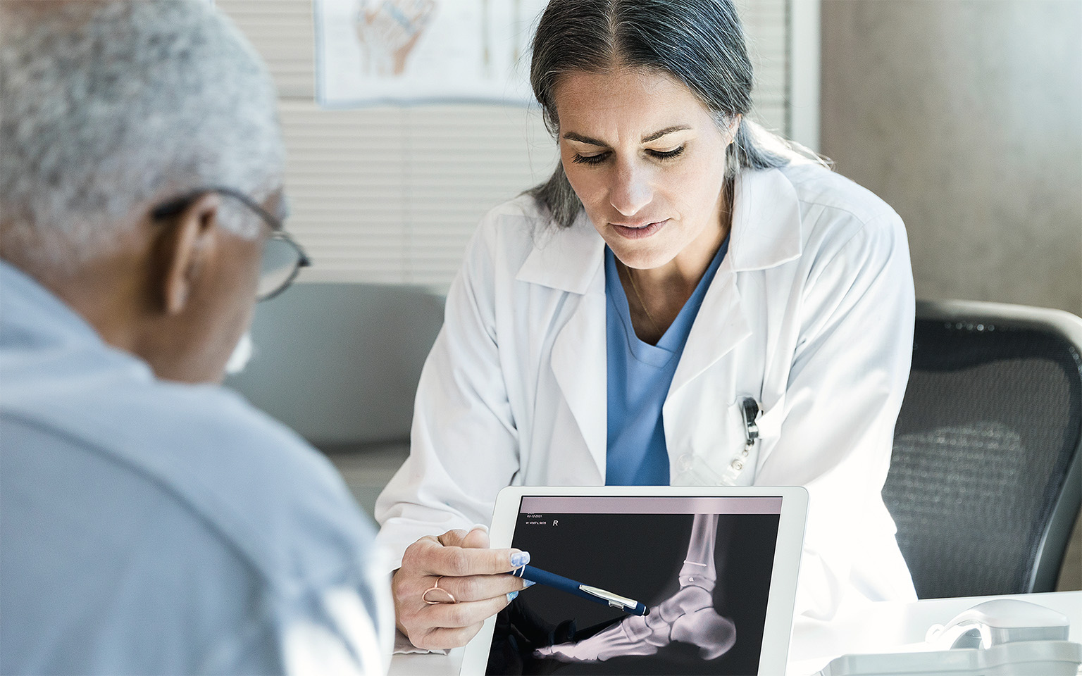 Orthopedic doctor reviewing patient foot X-ray