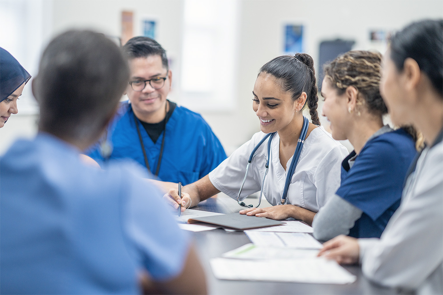 Medical professionals gather around to discuss patient cases